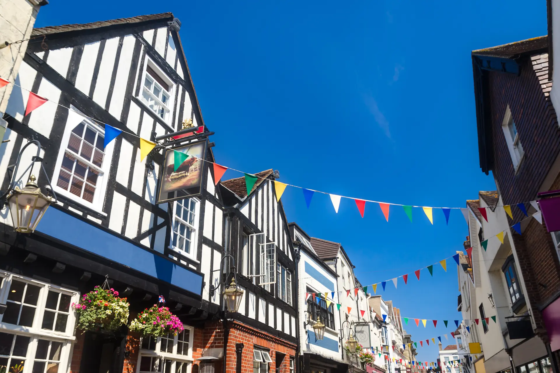 Tudor buildings and bunting on a busy English high street with independent shops